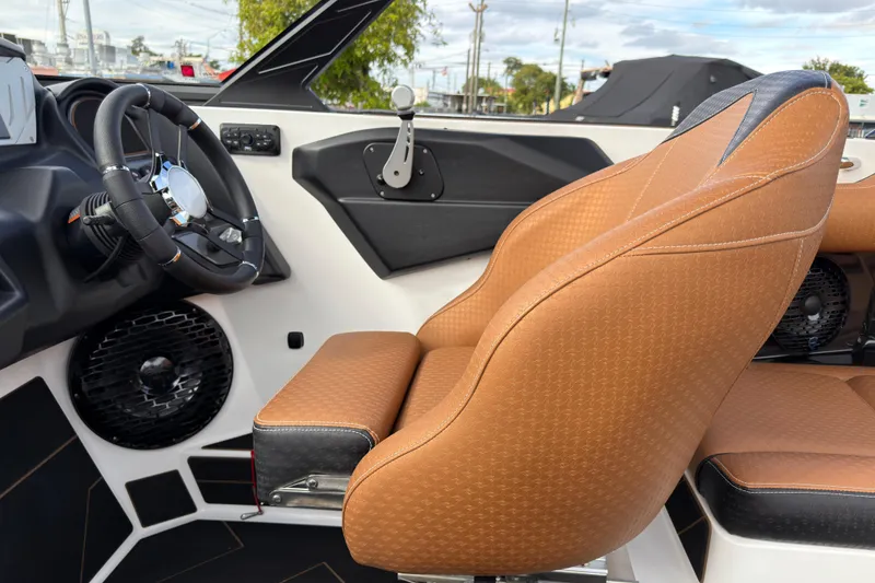 Slide: The Image of 2025 Supreme S220 boat interior with brown leather seats and modern steering wheel. - 19