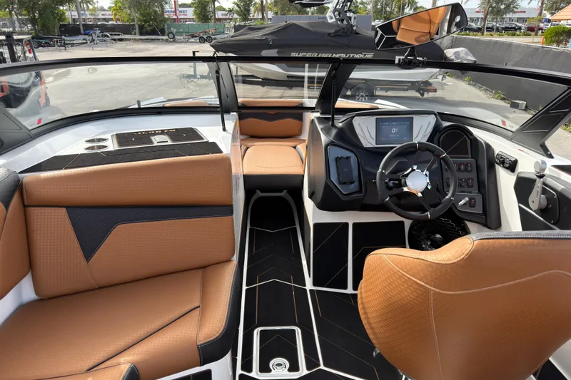 Slide: The Image of 2025 Supreme S220 boat interior with modern dashboard and tan seating. - 22