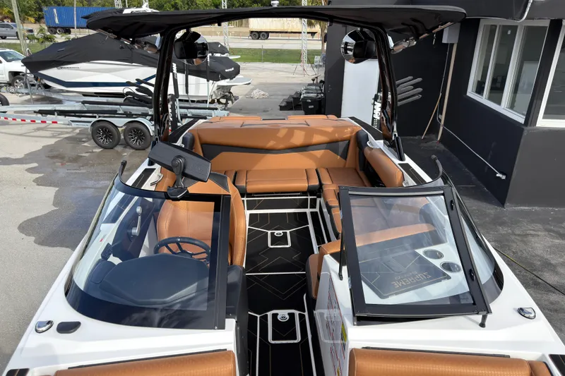Slide: The Image of 2025 Supreme S220 boat interior with tan seating and sleek black accents. - 24