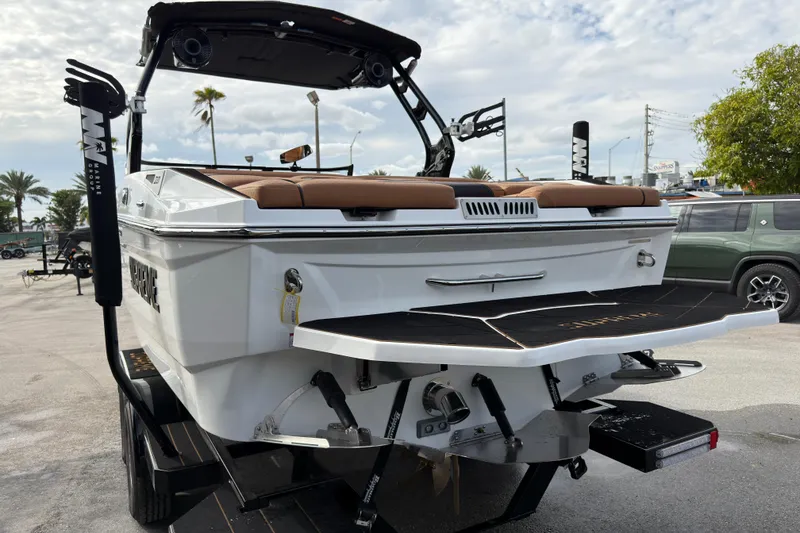 Slide: The Image of 2025 Supreme S220 boat, rear view, on trailer, with brown seating and modern design. - 7