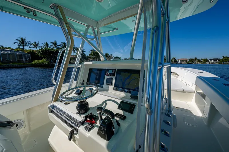Slide: The Image of 2017 SeaVee 390Z boat cockpit with steering wheel and navigation screens, on a sunny day. - 12
