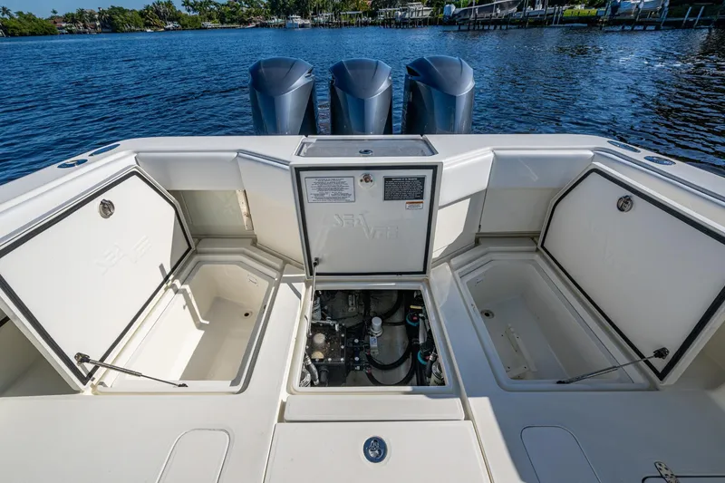 Slide: The Image of 2017 SeaVee 390Z boat with open storage compartments and triple outboard engines. - 16