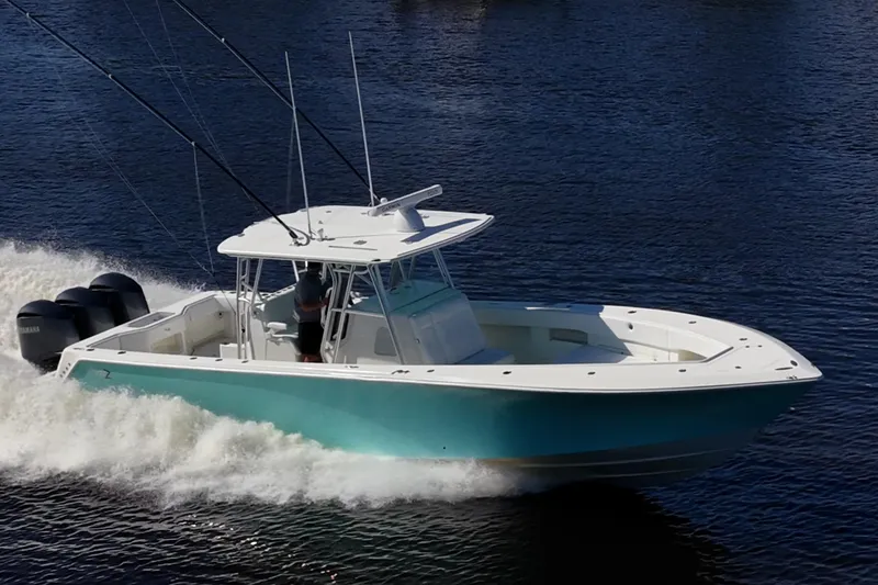 Slide: The Image of 2017 SeaVee 390Z boat cruising on water with fishing rods and triple engines. - 2