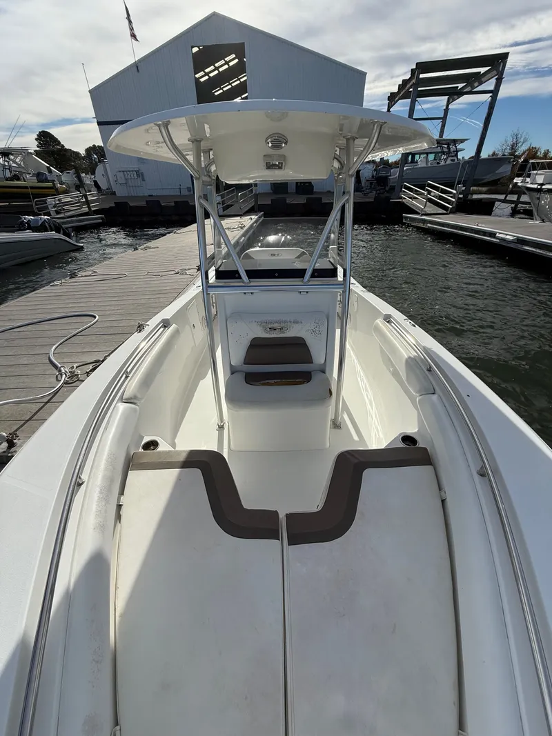 Slide: The Image of 2012 Sea Hunt Triton 240 boat docked at marina, showcasing spacious deck and seating. - 11