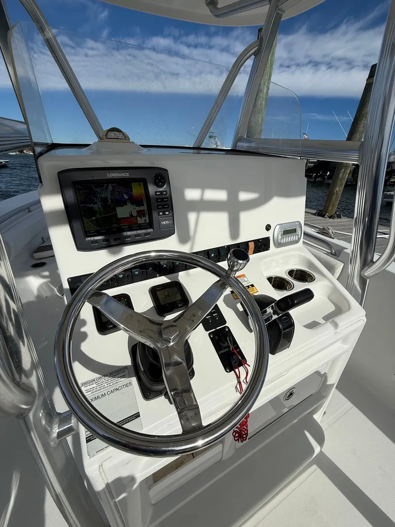 Slide: The Image of 2012 Sea Hunt Triton 240 boat console with steering wheel and navigation equipment. - 13