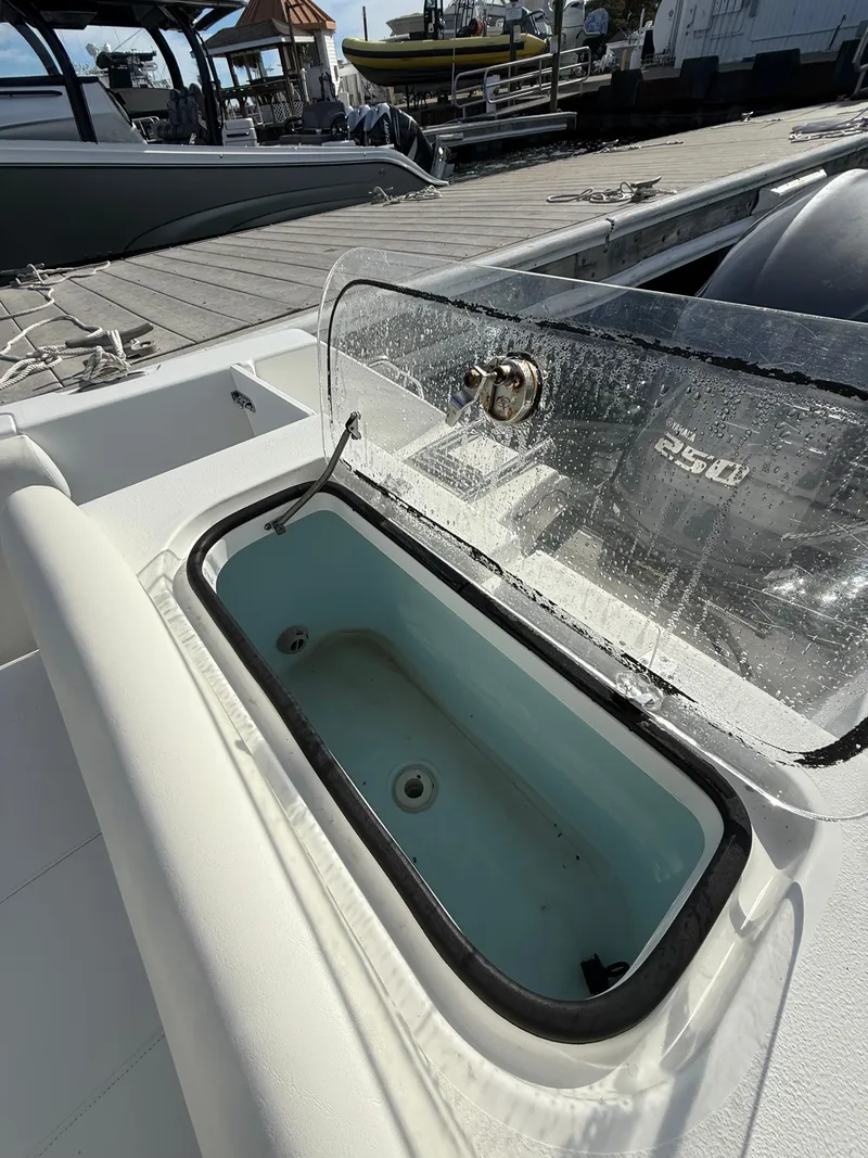 Slide: The Image of Open livewell on 2012 Sea Hunt Triton 240 boat at dock. - 15