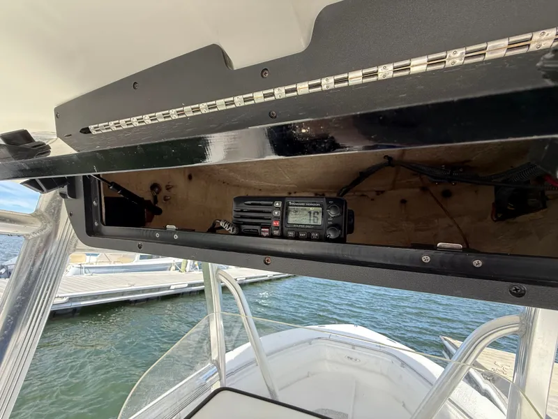 Slide: The Image of 2012 Sea Hunt Triton 240 boat with radio equipment in storage compartment. - 18