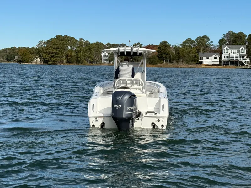 Slide: The Image of 2012 Sea Hunt Triton 240 boat on water, Yamaha engine, scenic background. - 2