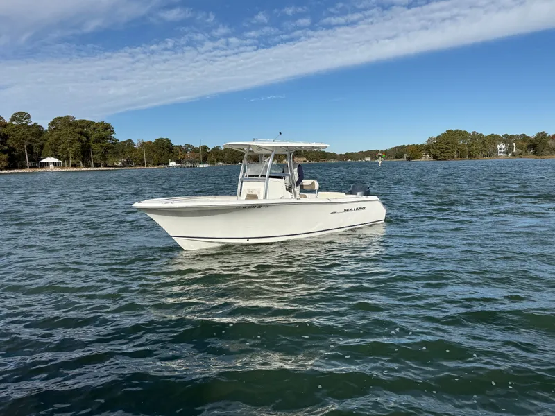 Slide: The Image of 2012 Sea Hunt Triton 240 boat on calm water under a clear blue sky. - 5