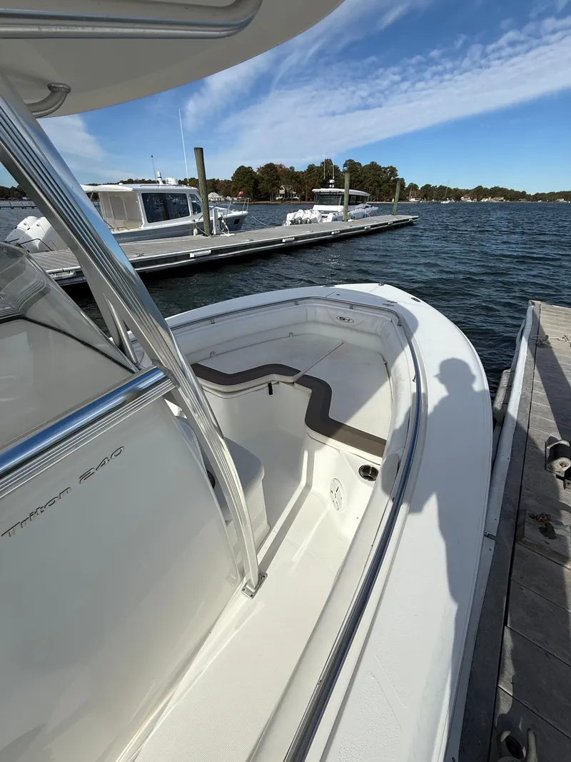 Slide: The Image of 2012 Sea Hunt Triton 240 boat docked by the water on a sunny day. - 7