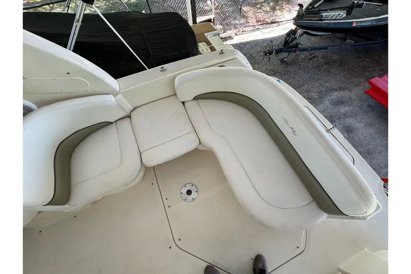 Slide: The Image of 2007 Sea Ray 260 Sundancer boat seating area with white and gray upholstery. - 10