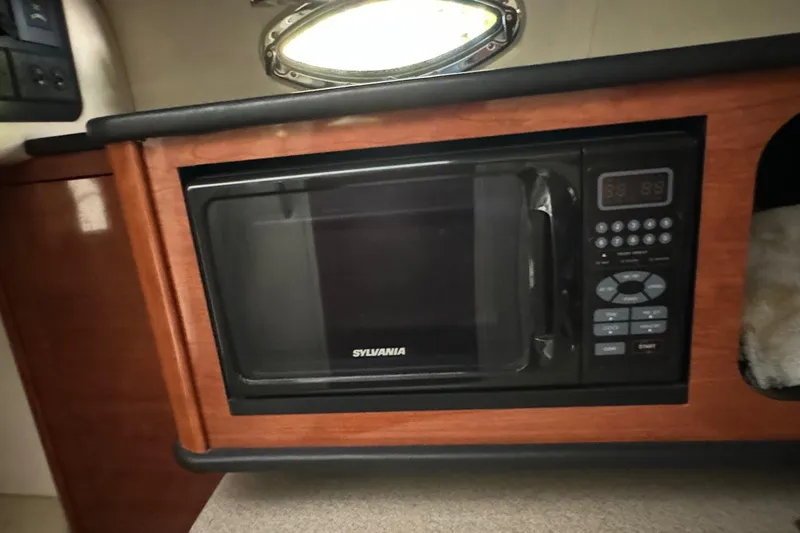 Slide: The Image of Microwave in 2007 Sea Ray 260 Sundancer cabin, featuring wood paneling and compact design. - 17