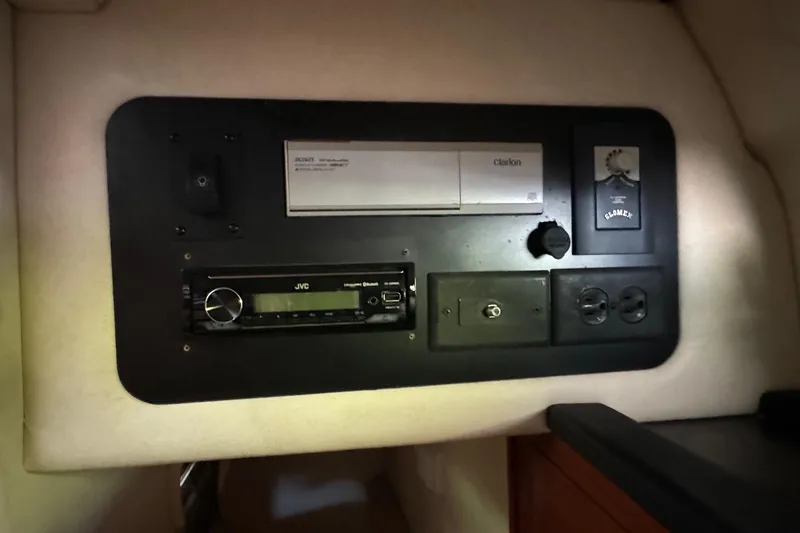 Slide: The Image of Control panel inside 2007 Sea Ray 260 Sundancer boat, featuring audio and electrical components. - 22