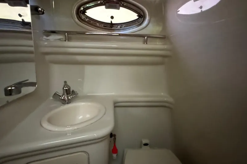 Slide: The Image of 2007 Sea Ray 260 Sundancer bathroom with sink, mirror, and porthole window. - 24