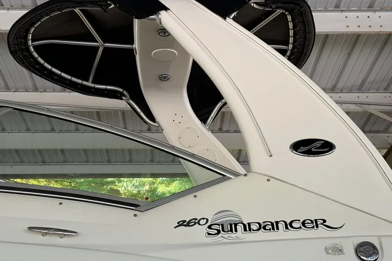 Slide: The Image of 2007 Sea Ray 260 Sundancer boat under a metal roof, showcasing sleek design and logo. - 5
