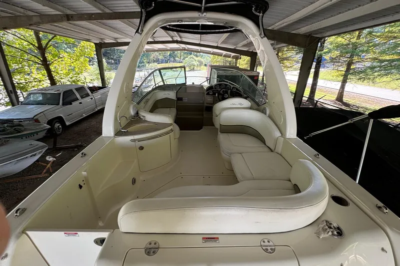 Slide: The Image of 2007 Sea Ray 260 Sundancer boat interior with white seating under a covered dock. - 8