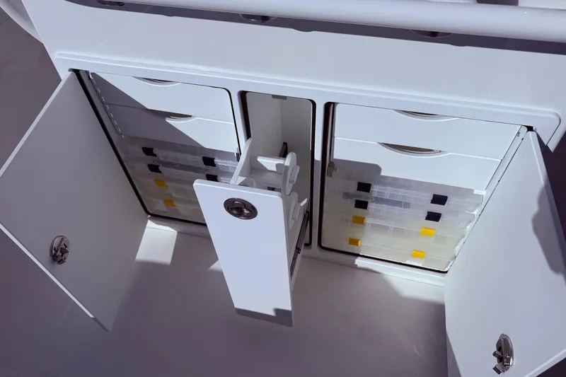 Slide: The Image of Open storage compartments on a 2026 Regulator 28 boat, featuring organized tackle boxes. - 13