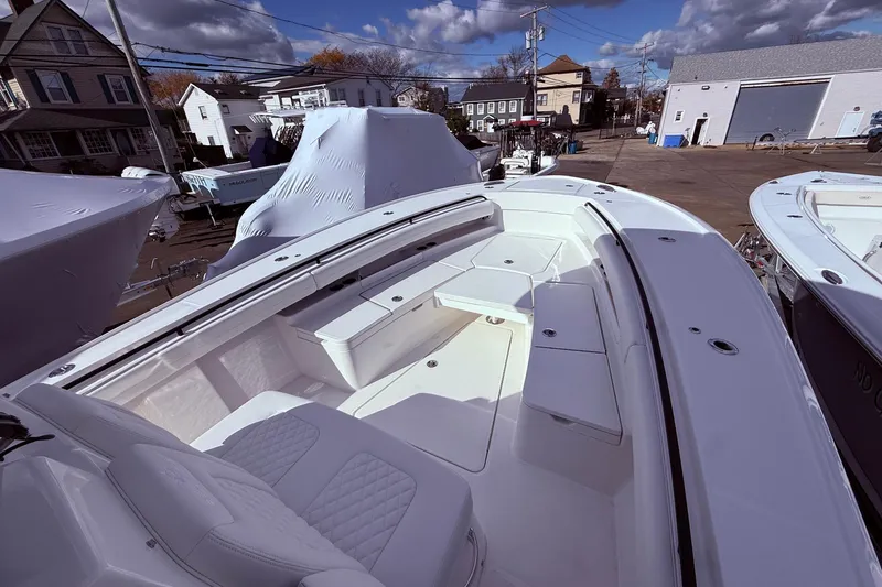 Slide: The Image of 2026 Regulator 28 boat with spacious seating, docked in a marina under a cloudy sky. - 26