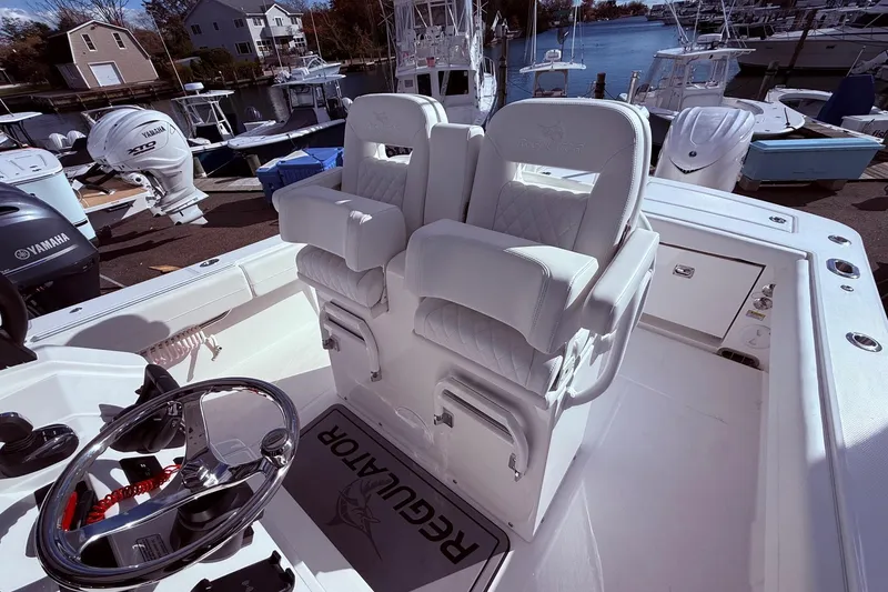 Slide: The Image of 2026 Regulator 28 boat interior with dual captain's chairs and Yamaha outboard engines. - 32
