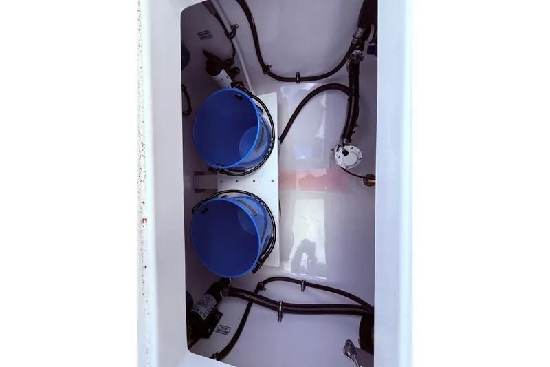 Slide: The Image of 2026 Regulator 28 boat storage compartment with blue buckets and wiring. - 35