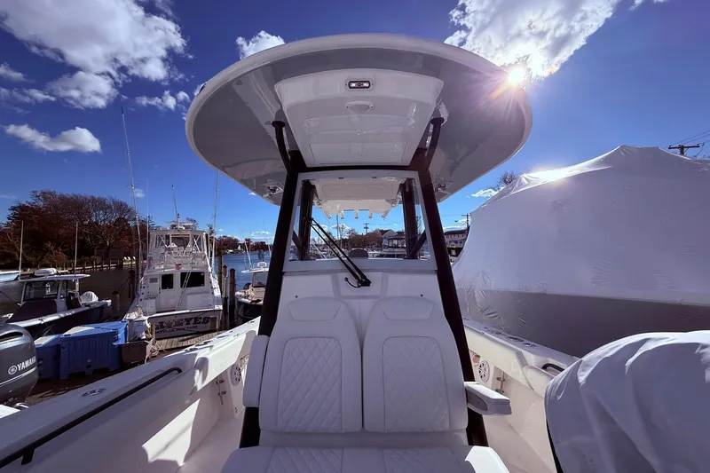 Slide: The Image of 2026 Regulator 28 boat interior with T-top, docked under a sunny sky. - 39