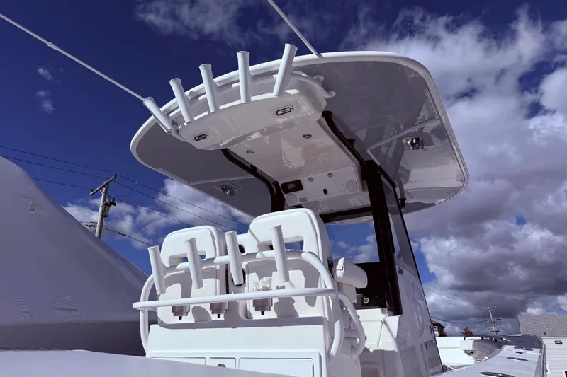 Slide: The Image of 2026 Regulator 28 boat with T-top and rod holders under a cloudy sky. - 4