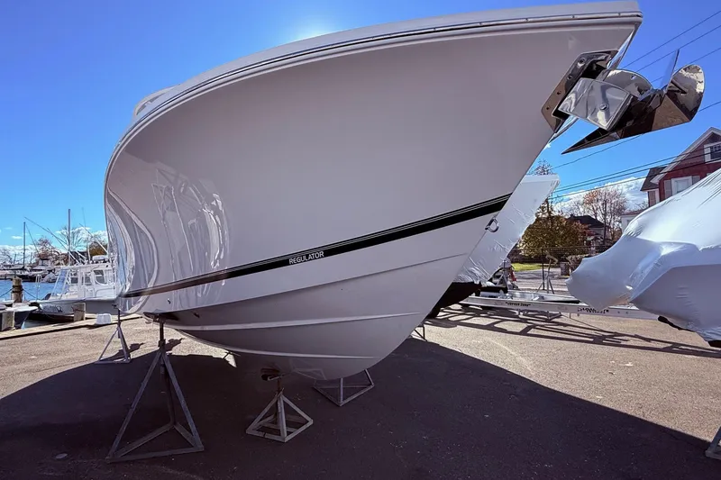 Slide: The Image of 2026 Regulator 28 boat on stands, displayed outdoors under clear blue sky. - 5