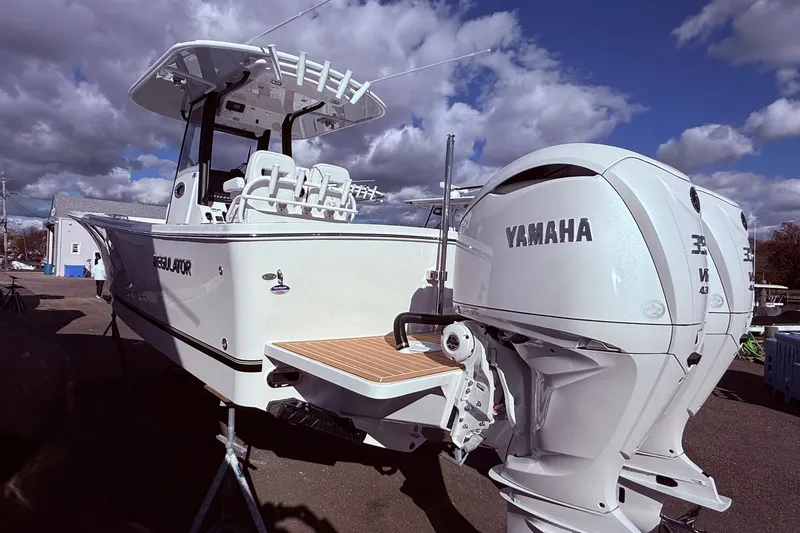 Slide: The Image of 2026 Regulator 28 boat with Yamaha engines, docked under a cloudy sky. - 6