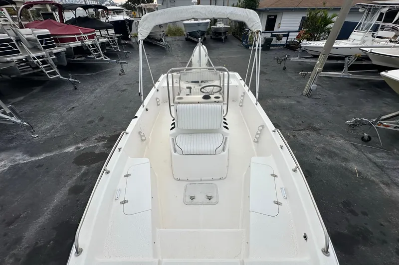 Slide: The Image of 2001 Century 2101 Bay Boat with canopy, parked in a marina, surrounded by other boats. - 10