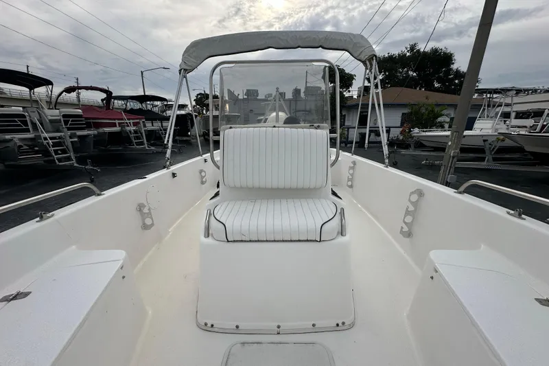 Slide: The Image of 2001 Century 2101 Bay Boat interior with white seating and canopy, docked at marina. - 12