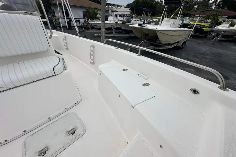 Slide: The Image of 2001 Century 2101 Bay Boat interior with seating and storage, parked among other boats. - 13