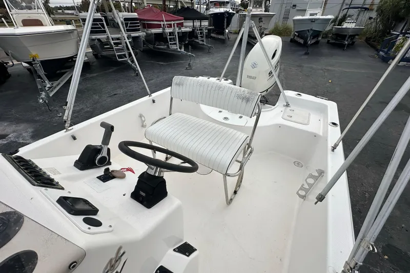 Slide: The Image of 2001 Century 2101 Bay Boat interior with steering wheel and seating, parked among other boats. - 16