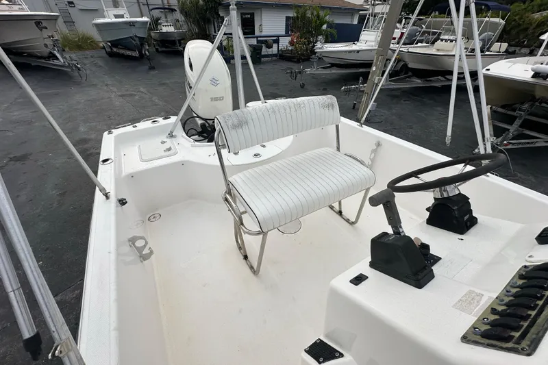 Slide: The Image of 2001 Century 2101 Bay Boat interior with steering wheel and seating, parked in a marina. - 18