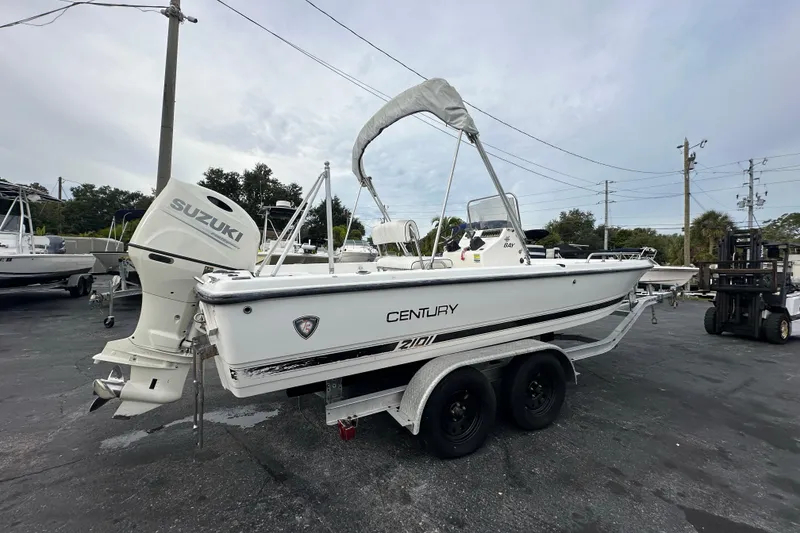 Slide: The Image of 2001 Century 2101 Bay Boat with Suzuki outboard on trailer, parked outdoors. - 6