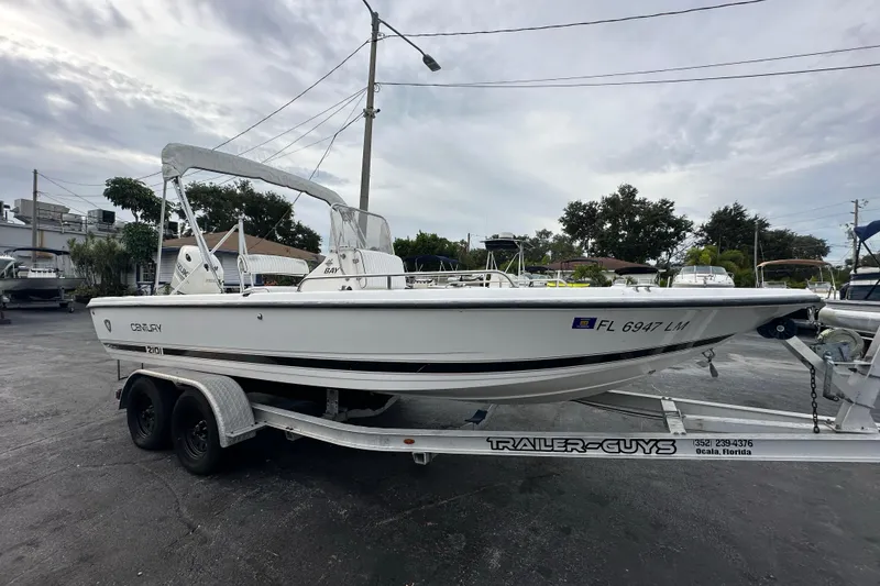 Slide: The Image of Century 2101 Bay Boat 2001 on trailer, parked outdoors under cloudy sky. - 8