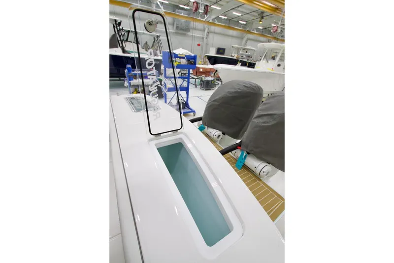 Slide: The Image of 2026 Regulator 31 boat interior with livewell and covered engines in a showroom. - 19