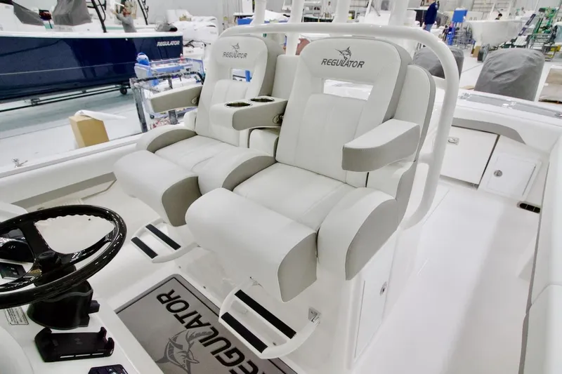 Slide: The Image of 2026 Regulator 31 boat interior with dual captain's chairs and steering wheel. - 29