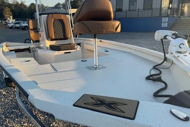 Slide: The Image of 2026 Xpress H20B Bay boat with brown seating and spacious deck, parked outdoors. - 5
