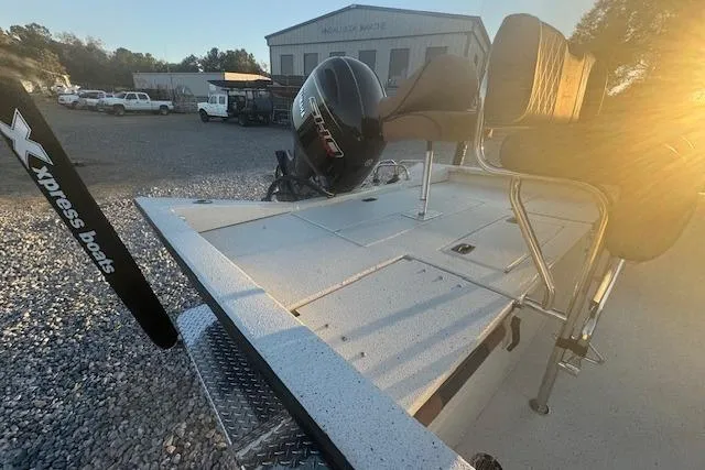 Slide: The Image of 2026 Xpress H20B Bay boat with motor, parked outdoors at sunset. - 7