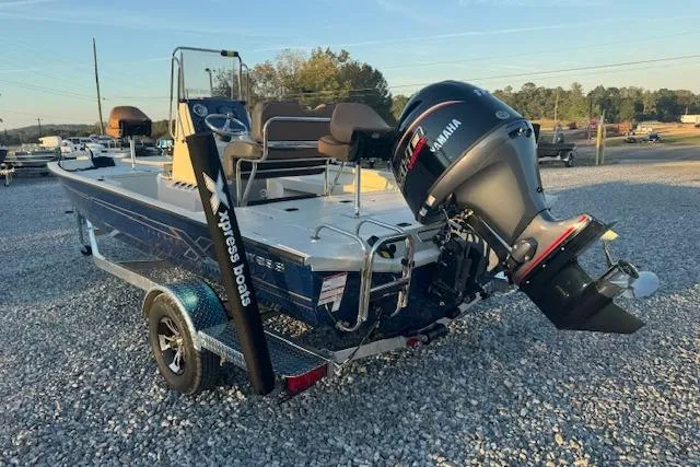 Slide: The Image of 2026 Xpress H20B Bay boat with Yamaha outboard motor on gravel lot. - 9