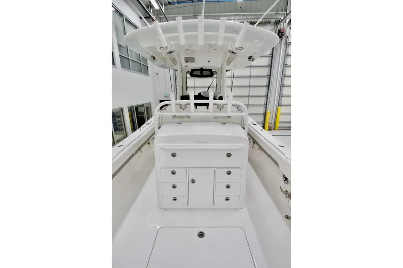 Slide: The Image of 2026 Regulator 31 boat interior with storage compartments and T-top in a showroom. - 24
