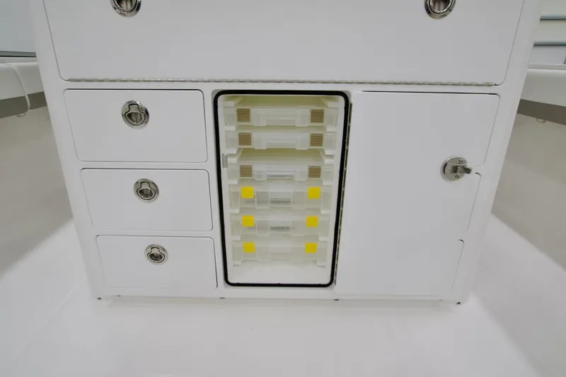Slide: The Image of 2026 Regulator 31 boat storage compartment with drawers and tackle boxes. - 27