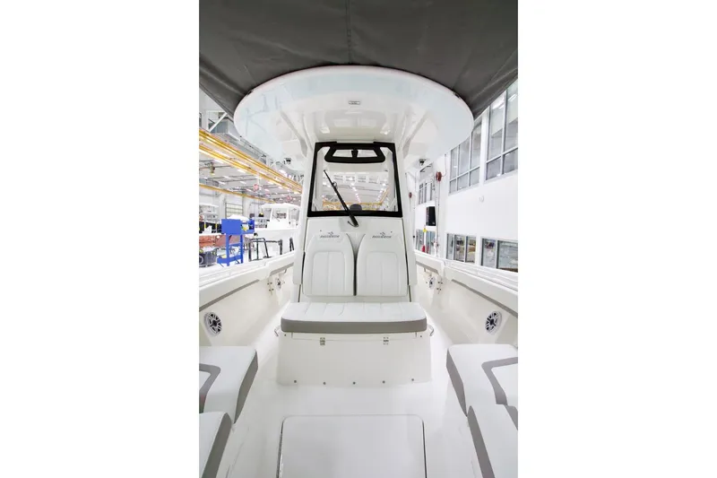 Slide: The Image of 2026 Regulator 31 boat interior, showcasing seating and helm in a modern factory setting. - 35