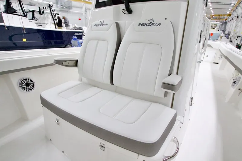 Slide: The Image of 2026 Regulator 31 boat interior with white cushioned seating and armrests. - 37