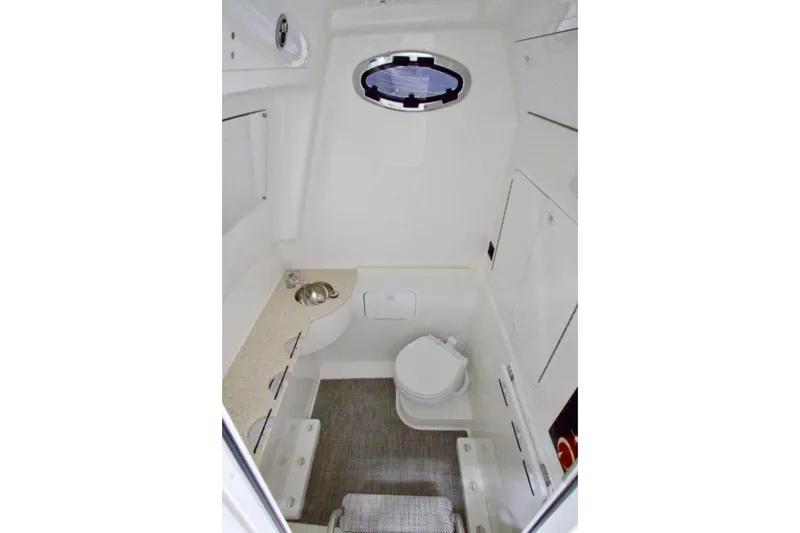 Slide: The Image of 2026 Regulator 31 boat interior with compact bathroom, featuring a toilet, sink, and storage cabinets. - 41