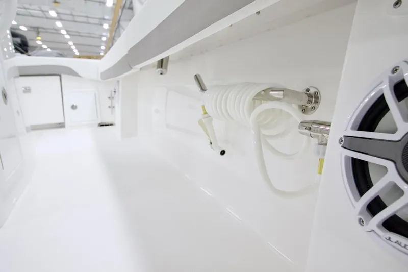 Slide: The Image of 2026 Regulator 31 boat interior with coiled hose and speaker in a sleek, white design. - 42