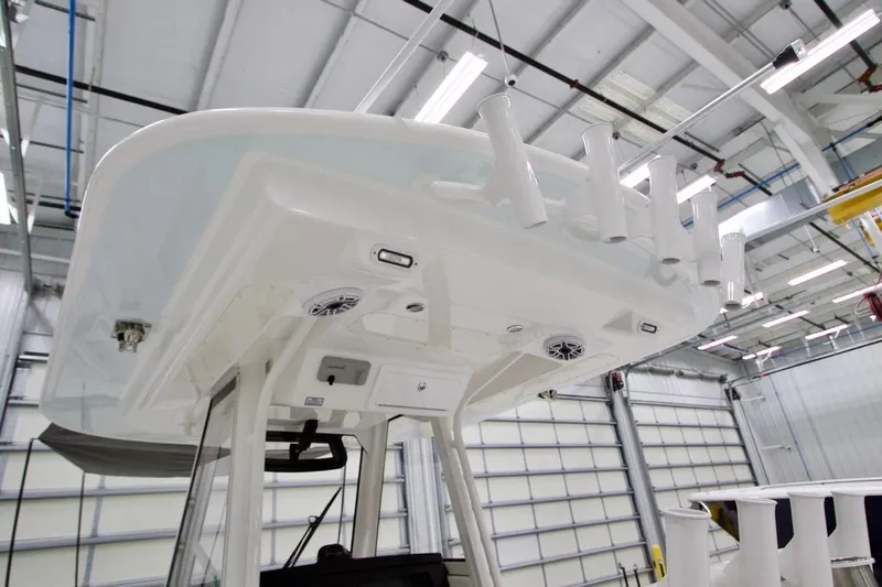 Slide: The Image of 2026 Regulator 31 boat interior with rod holders and speakers in a modern facility. - 44