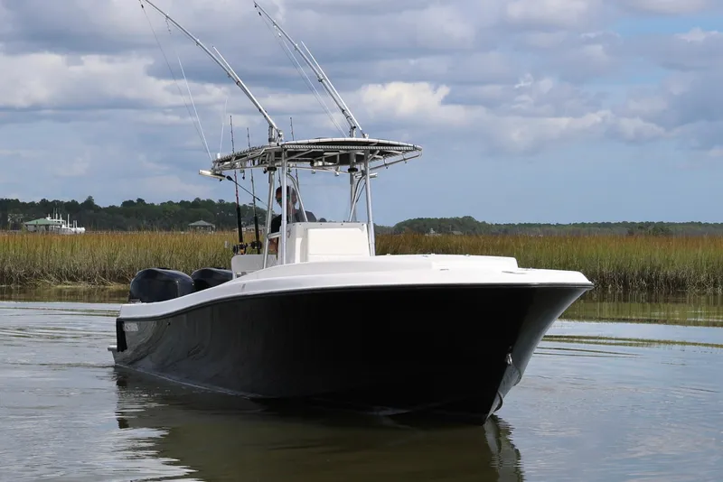 Slide: The Image of 2005 Contender 31 Cuddy boat interior with white seating and dual engines. - 11