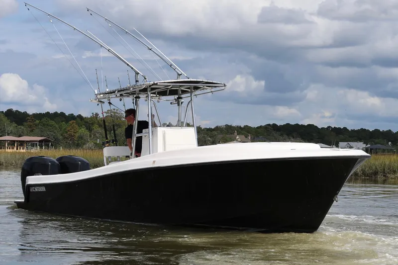 Slide: The Image of 2005 Contender 31 Cuddy boat interior with seating, on a calm river. - 13