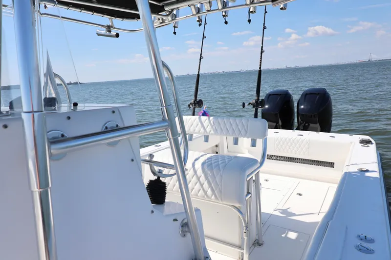 Slide: The Image of 2005 Contender 31 Cuddy boat interior with white seating and ocean backdrop. - 17